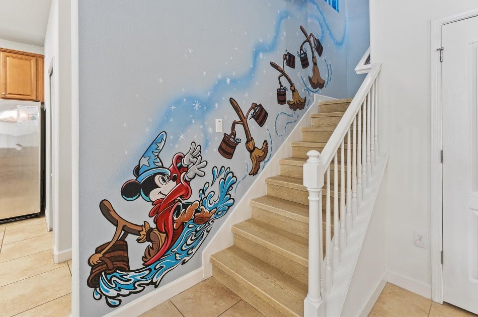 Mural of Mickey Mouse on the stairs in a themed Airbnb.