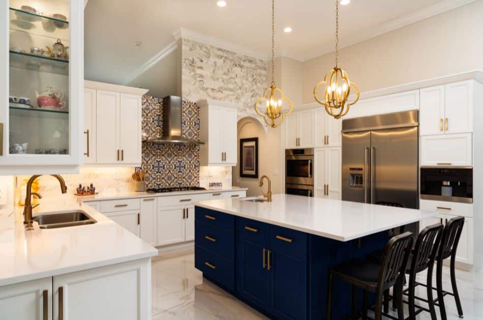 beautiful luxury estate home kitchen with blue cabinets on the kitchen island, white countertops, and white cabinets in the rest of the kitchen