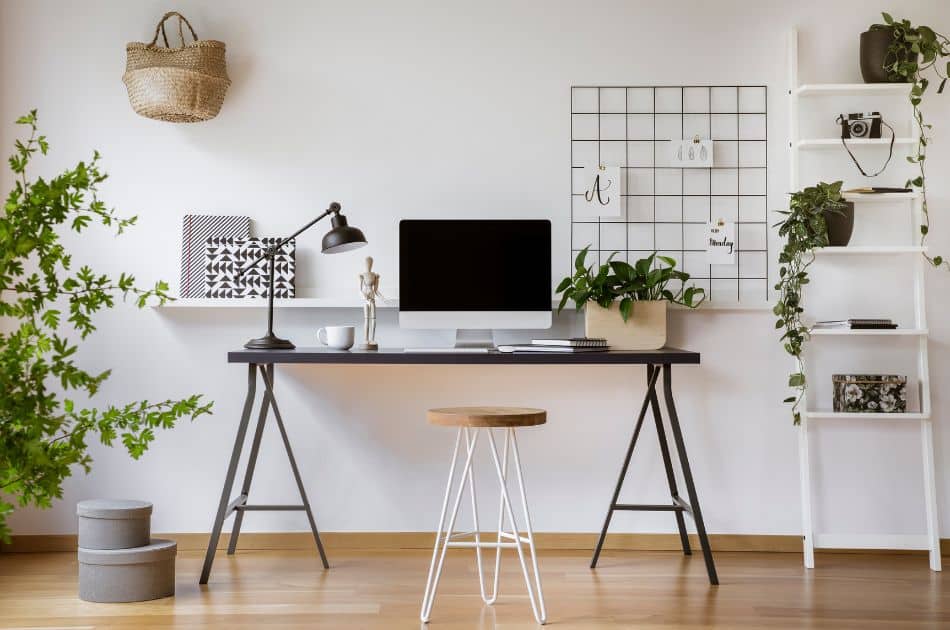 A well-organized home office with a desk, computer, and a plant nearby.