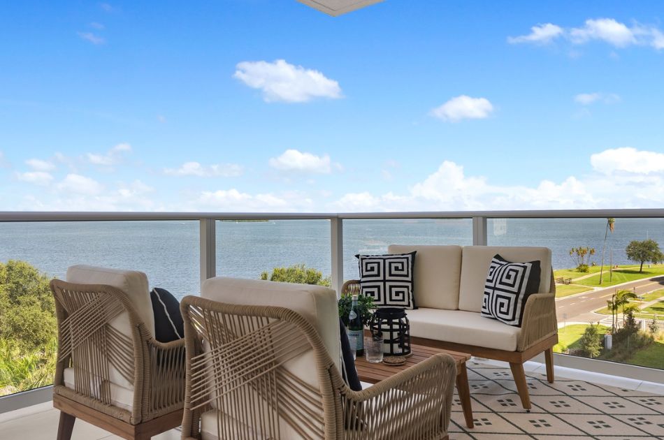 Outdoor balcony with seating area overlooking the water.